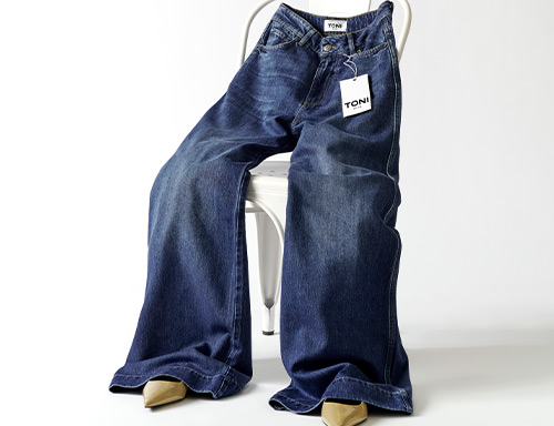 Jeans von TONI mit Etikett lässig über Stuhl gelegt – Teaser zur internationalen Retoure für Kundinnen aus Belgien