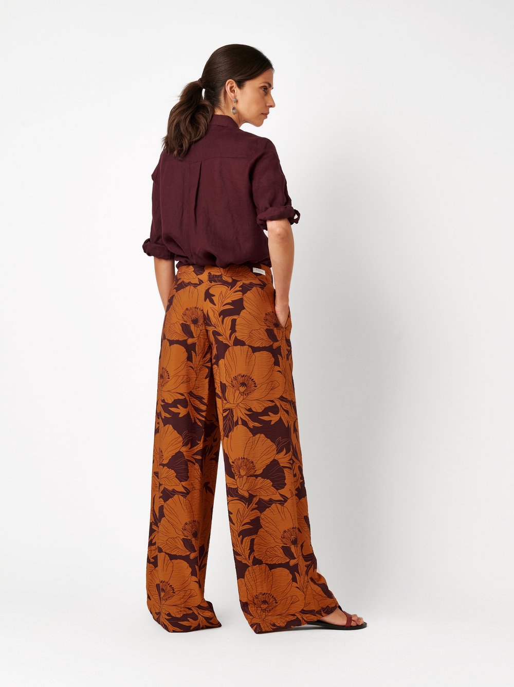 Womens trousers Elli Wide in orange, wide-leg pants with floral print and crepe texture, back view worn by model