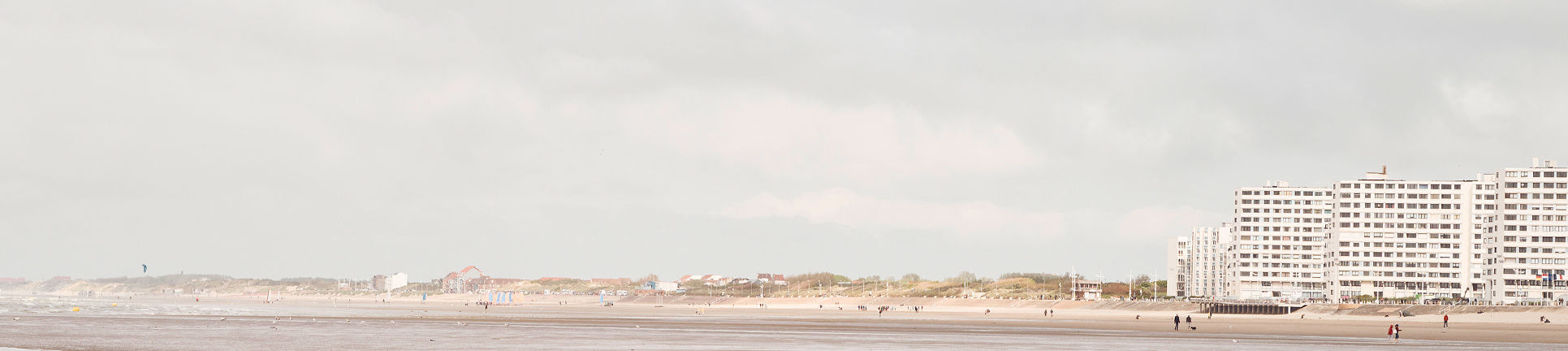 Weitläufiger Strand in Dunkerque mit Blick auf Dünen, Meer und Architektur – ruhiger Teaser zur Nachhaltigkeit.