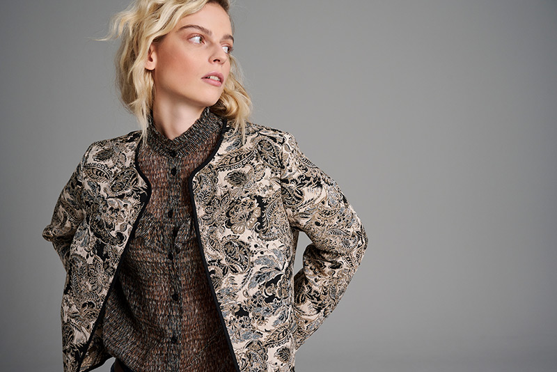 Woman looking sideways in patterned jacket – visual for customer service at TONI.